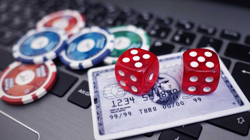 online casino payout laptop with credit card and dice
